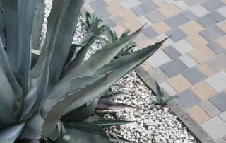 Pavimentazione in blocchi rettangolari multicolore disposti in pattern alternati con tonalità di grigio, marrone e antracite.
