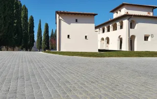 Strada pavimentata con blocchi in pietra anticata di colore grigio.