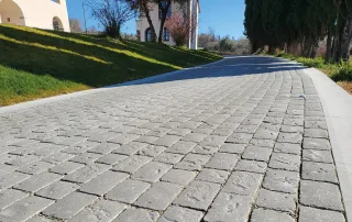 Strada pavimentata con blocchi in pietra anticata di colore grigio.
