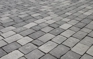 Pavimentazione in pietra anticata con blocchi di colore grigio.