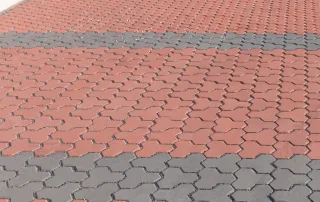 Pavimentazione drenante in cemento con blocchi ad incastro bicolore.