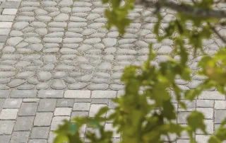Pavimentazione in pietra con combinazione di ciottoli arrotondati e blocchi squadrati.