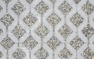 Pavimentazione in grigliato con forme a zig-zag, con pietre disposte su una base di ghiaia.