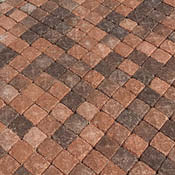 Pavimentazione in cubetti di porfido con finitura fiammata, caratterizzata da tonalità calde e sfumature naturali.
