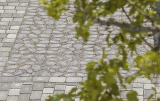 Pavimentazione in pietra con combinazione di ciottoli arrotondati e blocchi squadrati.