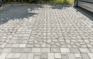 Pavimentazione in pietra con combinazione di ciottoli arrotondati e blocchi squadrati.