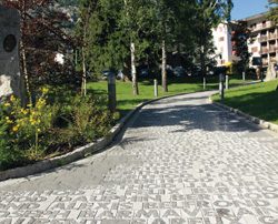 Pavimentazione in pietra con incisioni testuali bianche su sfondo grigio scuro