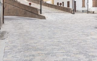 pavimentazione in pietra con blocchi rettangolari grigi e ocra.