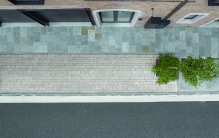 Vista dall'alto di una pavimentazione urbana in lastre di pietra naturale e autobloccanti.