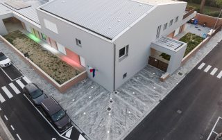 Masselli autobloccanti in cemento, posati a formare un motivo decorativo sul pavimento esterno presso la scuola fucini a Ponsacco.