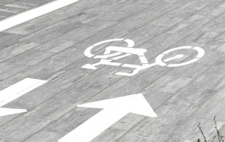 Pista ciclabile in masselli autobloccanti grigi.