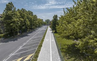 Pista ciclabile in masselli autobloccanti grigi.