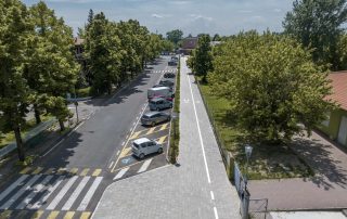 Pista ciclabile in masselli autobloccanti grigi.