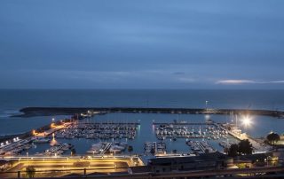 Passeggiata illuminata a LED nel porto di Cetraro, con barche ormeggiate di notte.