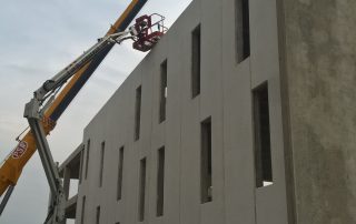 Montaggio di un edificio prefabbricato in cemento armato con l'ausilio di una gru.