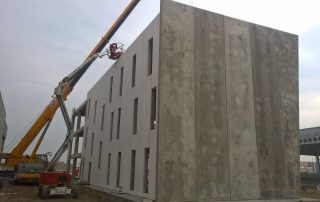 Montaggio di un edificio prefabbricato in cemento armato con l'ausilio di una gru.