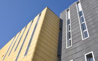 Edificio con pannelli prefabbricati in cemento giallo e grigio.