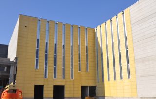 Edificio industriale con pannelli prefabbricati in cemento giallo.