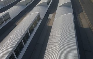 Copertura industriale con lucernari a shed in metallo e vetro.