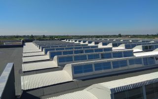 Copertura industriale con lucernari a shed in metallo e vetro.