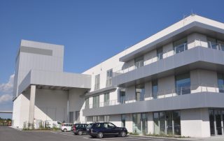 Edificio moderno con rivestimenti metallici e balconi sporgenti.