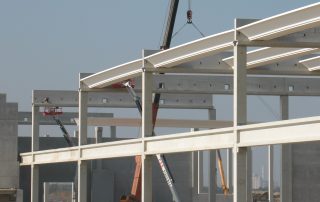 Assemblaggio di una struttura prefabbricata in cemento con travi metalliche.