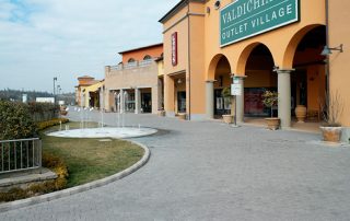 Pavimentazione in pietra dall'aspetto elegante e rustico all'ingresso del Valdichiana Outlet Village.