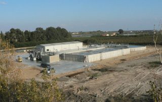 Impianto industriale con grandi vasche prefabbricate in cemento.