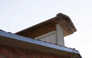 Un sistema di ventilazione in cemento posizionato sul colmo del tetto di una porcilaia.