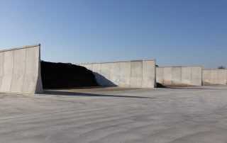 Vista di un'area di stoccaggio agricola con silos in cemento armato prefabbricato. Le pareti inclinate favoriscono un'efficiente gestione dei materiali.