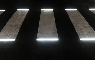Attraversamento pedonale illuminato da luci a LED integrate nelle strisce bianche, visto dall'alto di notte.