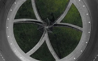 Illuminazione a LED integrata in una rotatoria stradale. Piccoli punti luce bianchi sono posizionati lungo il bordo del marciapiede.