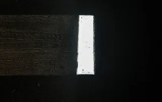 Attraversamento pedonale illuminato da luci a LED integrate nelle strisce bianche, visto dall'alto di notte.