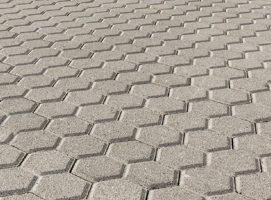 Pavimentazione in blocchi esagonali in cemento grigio.