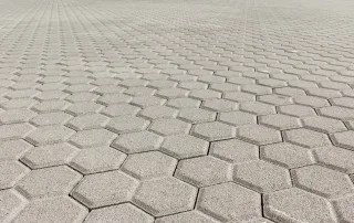 Pavimentazione in blocchi esagonali in cemento grigio.
