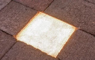 Pavimentazione in pietra con un elemento LED incassato.