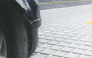 Pavimentazione drenante in calcestruzzo con elementi modulari e interspazi riempiti di ghiaia.