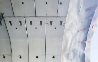 Vista dal basso del rivestimento interno di una galleria con pannelli prefabbricati in calcestruzzo.