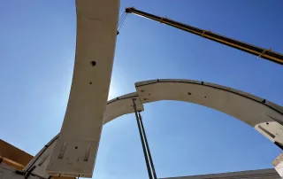 Vista dal basso del montaggio di elementi prefabbricati in calcestruzzo per il rivestimento di una galleria.