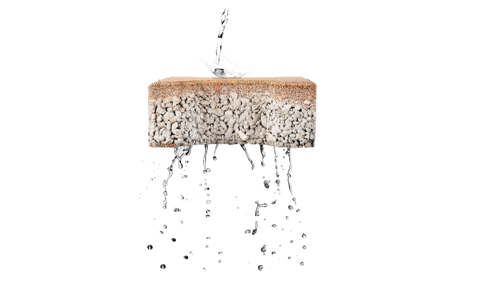Blocco drenante e filtrante in calcestruzzo con struttura porosa, che permette il passaggio dell'acqua per favorire il drenaggio sostenibile e ridurre il rischio di ristagni.