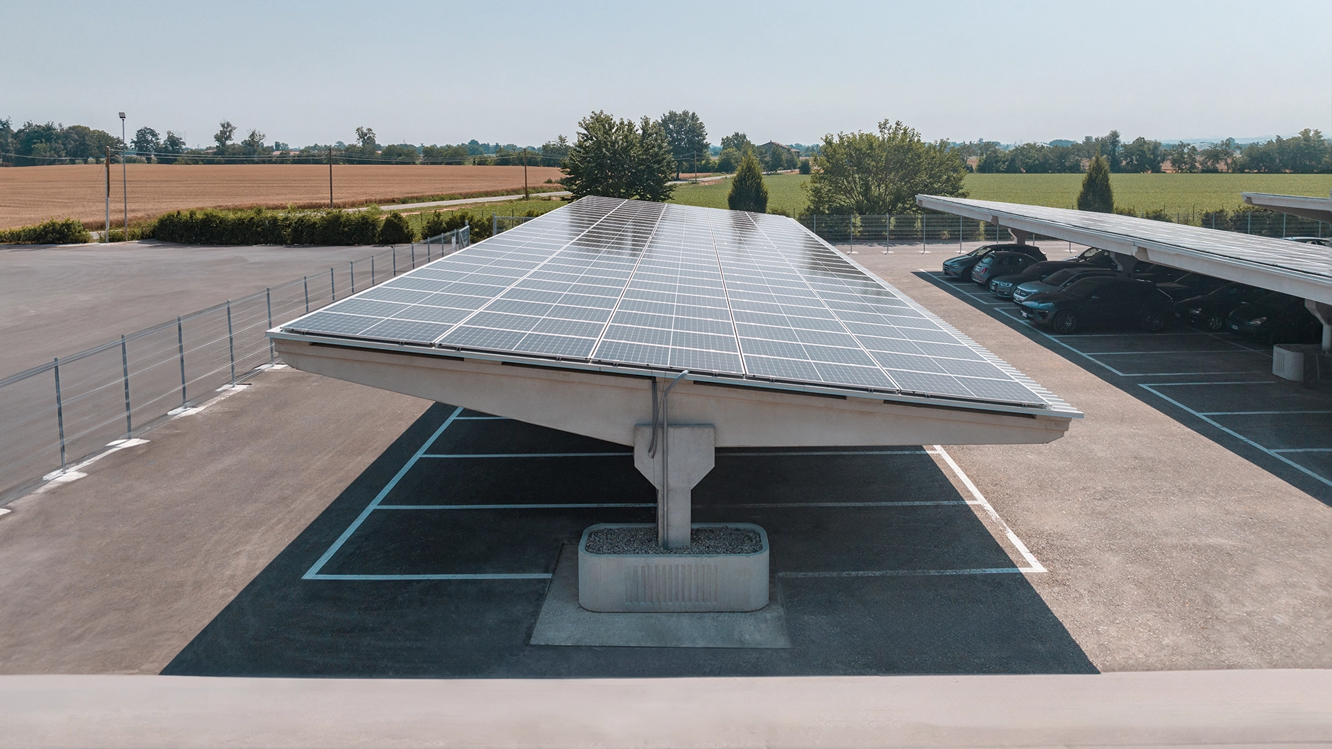 Parcheggio con pensiline fotovoltaiche in cemento dotate di pannelli solari.